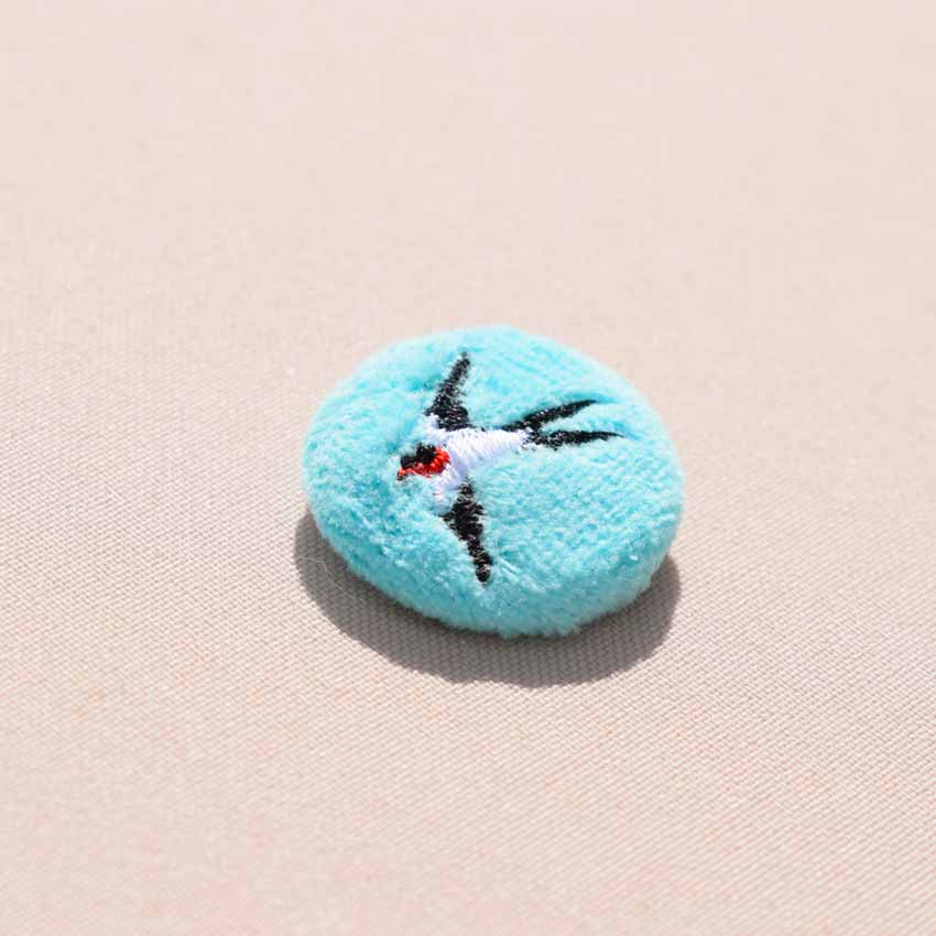 Mini broche brodée hirondelle en vol sur velours turquoise