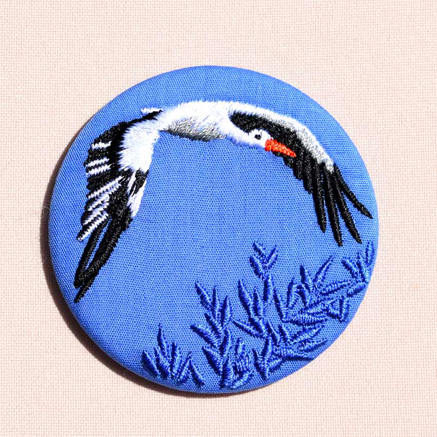broche brodée cigogne